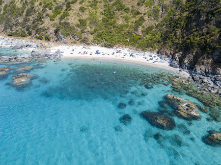 Paradise of the sub, beach with promontory overlooking the sea. Zambrone, Calabria, Italy. Diving relaxation and summer vacations. Italian coasts, beaches and rocks. Aerial viewの写真素材