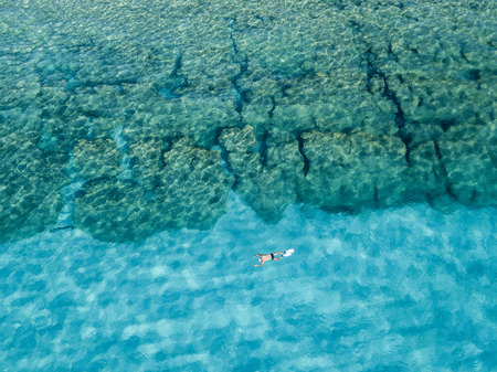 Aerial view of the rocks on the sea. Overview of seabed seen from above, transparent water. Swimmers, bathers floating on the water.の写真素材