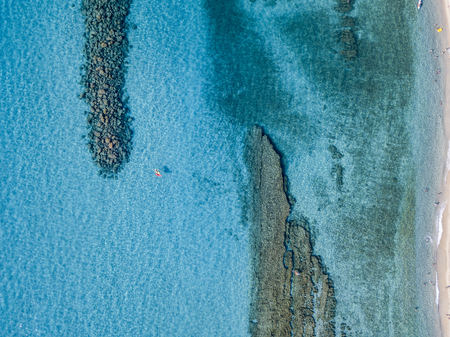 Aerial view of a canoe in the water floating on a transparent sea. Bathers at sea. Zambrone,...