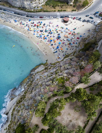 Aerial view of a beach with umbrellas and bathers. Promontory of the Sanctuary of Santa Maria dell'Isola, Tropea, Calabria, Italyの写真素材
