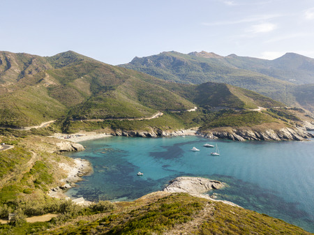 Aerial view of the coast of Corsica, winding roads and coves with crystalline sea. Cap Corse...