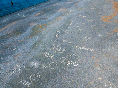 Aerial view of the black pebble beach, Nonza, Geometric designs made with stones, sailboats and moored boats near the beach. Cap Corse Peninsula, Corsica. Coastline. franceの写真素材
