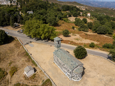 Aerial view of the church of San Michele de Murato, bell tower and aps. Surrounded by a square with trees. Northern Corsica. franceの写真素材