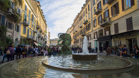 Pedestrian area of ??Corso Como, Milan, Italy. People walking. Fountain and shopsのeditorial素材