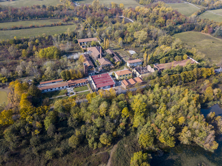 Nature and landscape: Aerial view of a furnace and chimney, woods and lakes, and green trees in a wild landscape. Groane Park, town of Mombello (Laghettone) Limbiate, Milano, Italyの写真素材