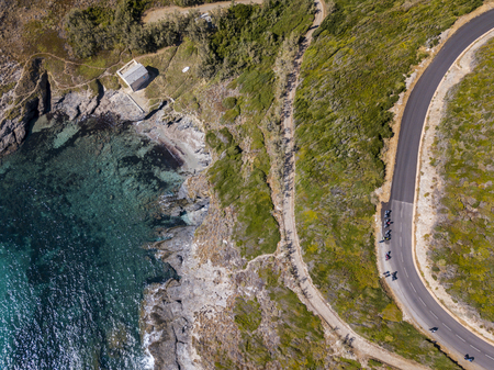 Aerial view of Corsica, winding roads and coves with crystalline sea. Motorcyclists parked on the edge of a road. Cap Corse Peninsula, Corsica. Coastline. Anse d'Aliso. Gulf of Aliso. franceの写真素材