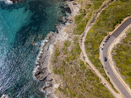 Aerial view of Corsica, winding roads and coves with crystalline sea. Motorcyclists parked on the edge of a road. Cap Corse Peninsula, Corsica. Coastline. Anse d'Aliso. Gulf of Aliso. franceの写真素材