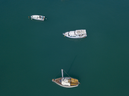 Aerial view of moored boats on a green sea