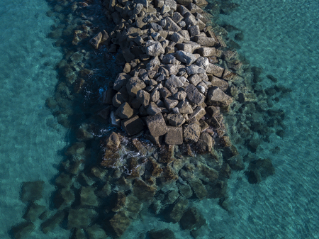 Aerial view of rocks on the sea. Seen from above, transparent waterの写真素材