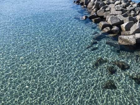 Aerial view of rocks on the sea. Seen from above, transparent waterの写真素材