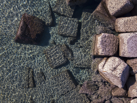 Aerial view of rocks on the sea. Seen from above, transparent waterの写真素材