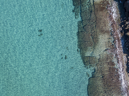 Aerial view of rocks on the sea. Seen from above, transparent waterの写真素材