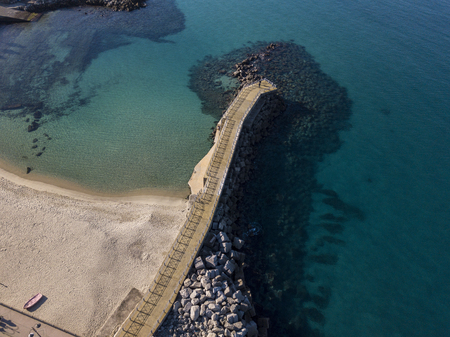 Aerial view of a pier with rocks and rocks on the sea. Pier of Pizzo Calabro, panoramic view from above. Summer sea and tourism on the Calabrian coast of Southern Italy. Calabria, Italyの写真素材