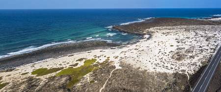 Aerial view of the Caleta del Mojón Blanco, sandy desert beach and rugged coastline. Orzola,...