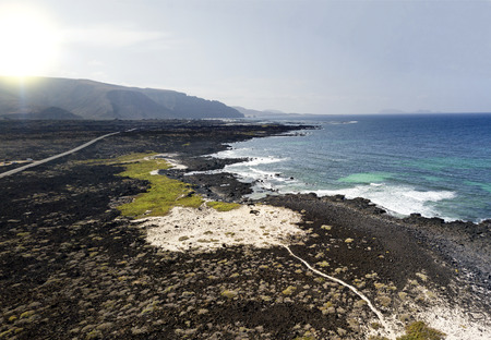 Aerial view of the Caleta del Mojón Blanco, sandy desert beach and rugged coastline. Orzola,...