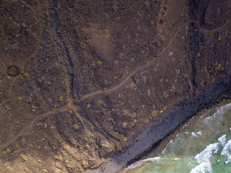 Aerial view of the mountainous coasts of the island of Lanzarote, Canary Islands, Spain. Africa. Reliefs overlooking the sea and dirt paths. Hiking trailsの写真素材