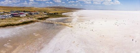Aerial view of Lake Tuz, Tuz Golu. Salt Lake. White salt water. It is the second largest lake in the world and one of the largest hypersaline lakes in the world. It is located in the Central Anatolia Region, Ankara, Aksaray, Konya. People standing in the middle of the salt lakeの写真素材
