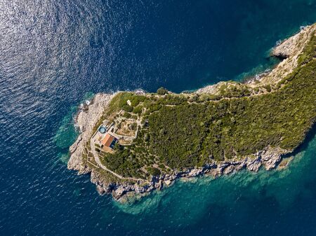 Aerial view of Sveti Nikola, Budva island, Montenegro. Jagged coasts with sheer cliffs overlooking the transparent sea. Wild nature and Mediterranean maquisの写真素材