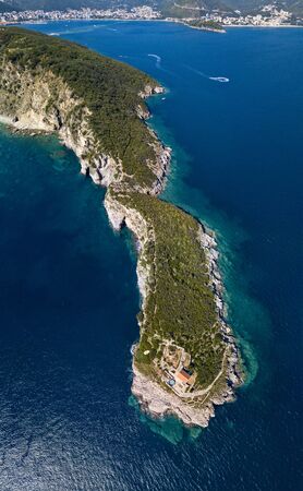 Aerial view of Sveti Nikola, Budva island, Montenegro. Jagged coasts with sheer cliffs overlooking the transparent sea. Wild nature and Mediterranean maquisの写真素材