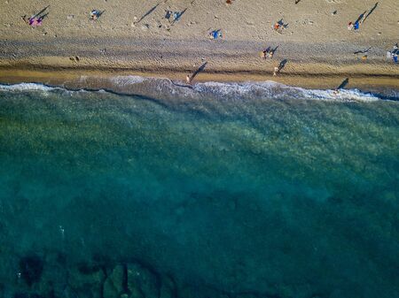 Aerial view of a beach with umbrellas and bathers at sunset. Seabed. Beach of Buljarica, one of the largest beaches in Montenegro, close to Petrovac in the direction of Bar. Budva municipalityの写真素材