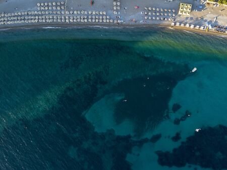 Aerial view of a beach with umbrellas and bathers at sunset. Seabed. Beach of Buljarica, one of the largest beaches in Montenegro, close to Petrovac in the direction of Bar. Budva municipalityの写真素材