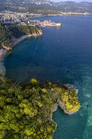 Aerial view of Mogren beach (two sandy beaches) and the old city (stari grad) of Budva, Montenegro. Jagged coast on the Adriatic Seaの写真素材