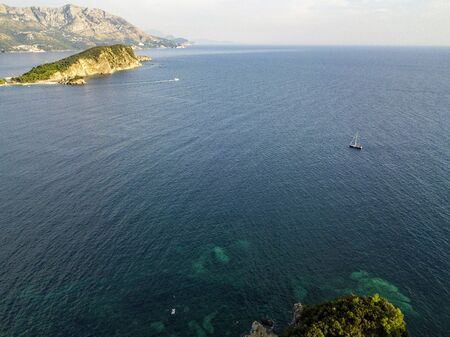 Aerial view of Sveti Nikola, Budva island, Montenegro. Jagged coasts with sheer cliffs overlooking the transparent sea. Wild nature and Mediterranean maquisの写真素材