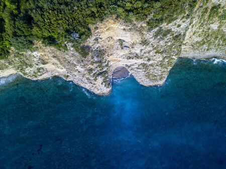 Aerial view of Sveti Nikola, Budva island, Montenegro. Jagged coasts with sheer cliffs overlooking the transparent sea. Wild nature and Mediterranean maquisの写真素材
