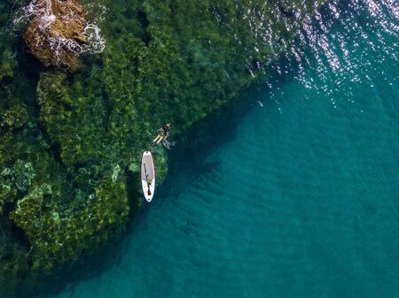 Aerial view of a snorkeling board. Bathers at sea. Tropea, Calabria, Italy. Diving relaxation and summer vacations. Italian coasts, beaches and rocks.の写真素材