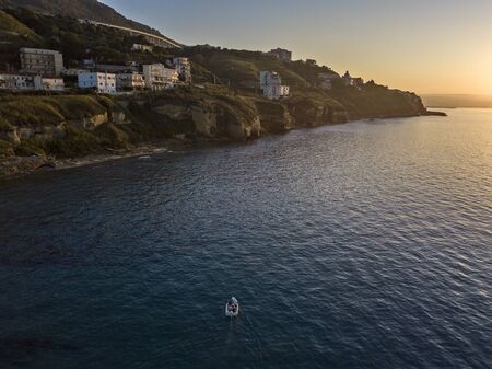 Aerial view of a boat seen from above, powered by an engine. Blue sea that surrounds a boat that crosses it. People inside a boat. 22/10/2019. Pizzo Calabro, Calabria, Italyの写真素材