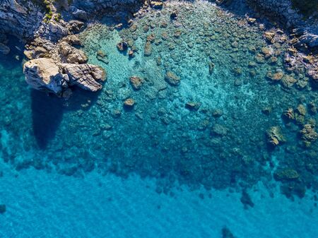 Aerial view of Tropea beach, crystal clear water and rocks that appear on the beach. Calabria, Italy. Swimmers, bathers floating on the water. Tyrrhenian Sea. Coastline of Calabriaの写真素材
