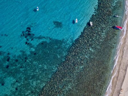 Aerial view of boats at the Tropea beach, deck chairs and umbrellas by the sea. Crystal and clear water. Calabria, Italyの写真素材