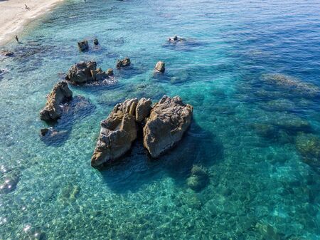 Aerial view of Tropea beach, crystal clear water and rocks that appear on the beach. Calabria, Italy. Swimmers, bathers floating on the water. Tyrrhenian Sea. Coastline of Calabriaの写真素材