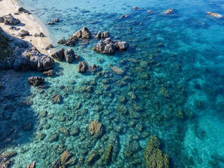Aerial view of Tropea beach, crystal clear water and rocks that appear on the beach. Calabria, Italy. Swimmers, bathers floating on the water. Tyrrhenian Sea. Coastline of Calabriaの写真素材