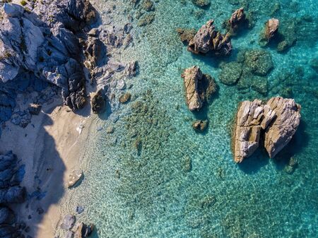 Aerial view of Tropea beach, crystal clear water and rocks that appear on the beach. Calabria, Italy. Swimmers, bathers floating on the water. Tyrrhenian Sea. Coastline of Calabriaの写真素材