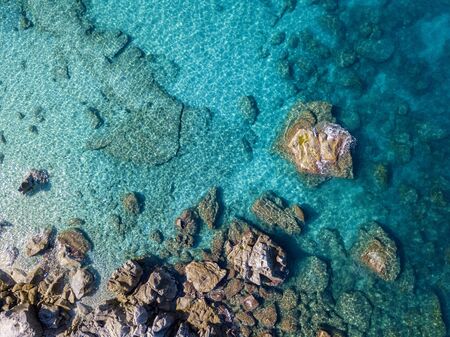Aerial view of Tropea beach, crystal clear water and rocks that appear on the beach. Calabria, Italy. Swimmers, bathers floating on the water. Tyrrhenian Sea. Coastline of Calabriaの写真素材