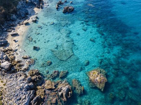 Aerial view of Tropea beach, crystal clear water and rocks that appear on the beach. Calabria, Italy. Swimmers, bathers floating on the water. Tyrrhenian Sea. Coastline of Calabriaの写真素材