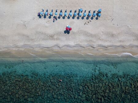 Aerial view of a beach and umbrellas. Tropea, Calabria, Italy. Overview of seabed seen from above, transparent water. Swimmers, bathers floating on the water. Lido La Graziaの写真素材