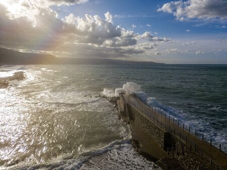 Aerial view of a pier with rocks and rocks on the sea. Pizzo Calabro pier, panoramic view from above. Broken pier, force of the sea. Power of Waves. Natural disasters, climate change. Calabria, Italyの写真素材