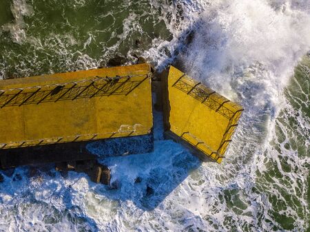 Aerial view of a pier with rocks and rocks on the sea. Pizzo Calabro pier, panoramic view from above. Broken pier, force of the sea. Power of Waves. Natural disasters, climate change. Calabria, Italy.の写真素材