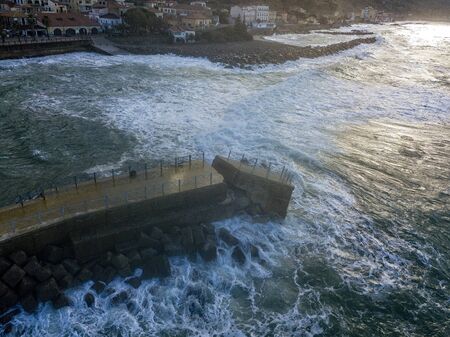 Aerial view of a pier with rocks. Pizzo Calabro pier, panoramic view from above. Broken pier, force of the sea. Power of Waves. Natural disasters, climate change. Calabria, Italy.の写真素材