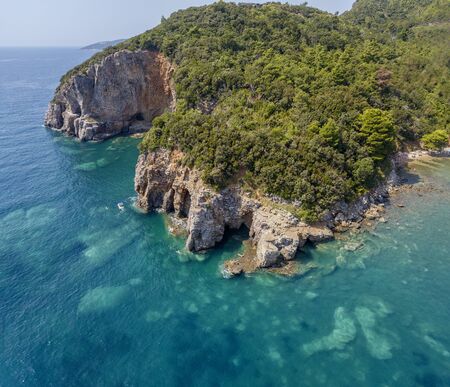 Aerial view of Mogren promontory between the Mogren beaches. Budva. Montenegro. Jagged coasts with sheer cliffs overlooking the transparent sea. Wild nature and Mediterranean maquisの写真素材