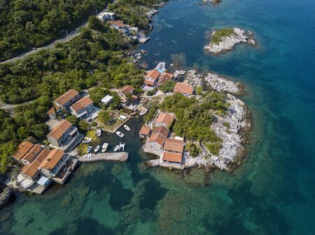 Aerial view of Kakrc in the Kotor fjord in Montenegro. Houses and buildings on the sea. Mediterranean maquis vegetation and unspoiled natureの写真素材
