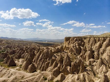 Aerial view of Goreme National Park, Goreme Tarihi Milli Parki, Turkey. The typical rock formations of Cappadocia with fairy chimneys and desert landscape. Travel destinations, holidays and adventureの写真素材