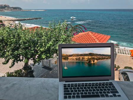 Smart working, work station. Working while on vacation. Choosing the right place to work from home. Covid-19 changes in the world of work. Computer, internet connection. Tropea. Italyの写真素材