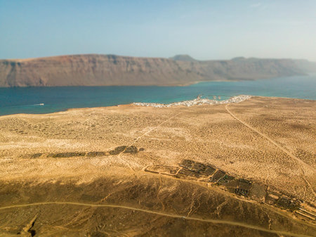 Aerial view of Caleta de Sebo, the main settlement and capital community of La Graciosa, Canary Islands. In the background El risco, the mountainous part to the north of Lanzaroteの写真素材