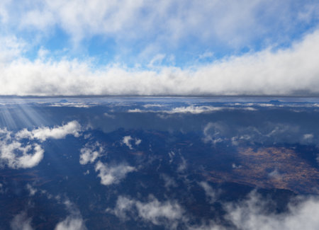 Aerial view of a mountain range in the clouds. Clouds that envelop a panorama of mountains and sun rays that cross them. 3d renderの写真素材
