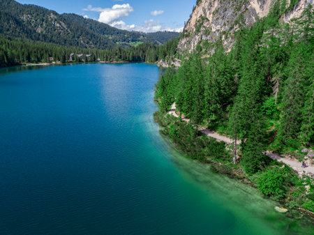 Aerial view of the Lake Braies, Pragser Wildsee is a lake in the Prags Dolomites in South Tyrol, Italy. People walking and trekking along the paths that run along the lakeの写真素材