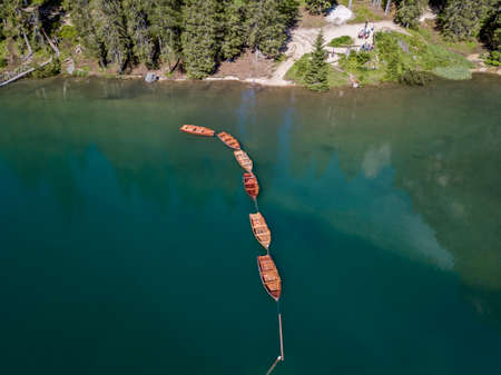 Aerial view of the Lake Braies, Pragser Wildsee is a lake in the Prags Dolomites in South Tyrol, Italy. View of rowboats moored in lineの写真素材