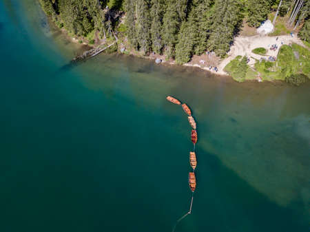 Aerial view of the Lake Braies, Pragser Wildsee is a lake in the Prags Dolomites in South Tyrol, Italy. View of rowboats moored in lineの写真素材